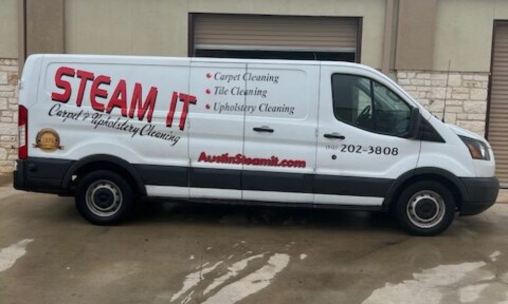 A white van parked in front of a building.