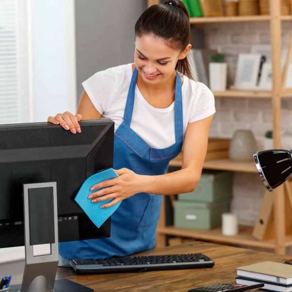 A woman in an apron cleaning the computer.